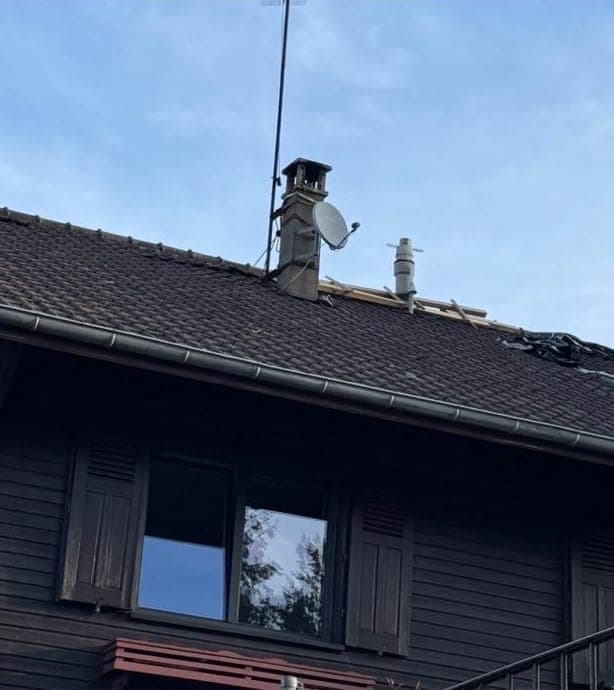 Chalet à bardage bois, couverture sombre aux tuiles déplacées avant travaux